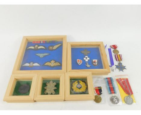 Replica WWI & WWII medals, RAF wings, enamel badges and a miniature penny, some framed and glazed. 