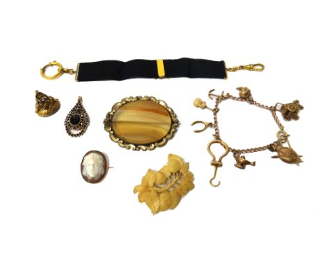 A gold curb link charm bracelet, fitted with eight mostly 9ct gold pendants and charms, including a folding button hook, a ba