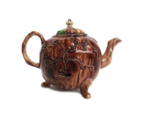 A Whieldon-type creamware teapot and a matched cover, circa 1770, of bullet form raised on three lion mask and paw feet, spri