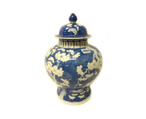 A Chinese blue and white baluster vase and cover, late 19th century, painted with prunus on a `cracked ice' ground, six chara