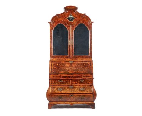 An 18th century Dutch feather banded figured walnut bureau cabinet, the shaped bonnet top over pair of arch mirror panel door