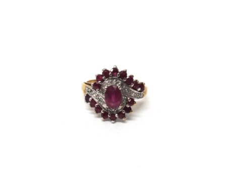 A 9ct gold, ruby and diamond ring, in a spiral cluster design, claw set with the principal oval cut ruby at the centre and wi