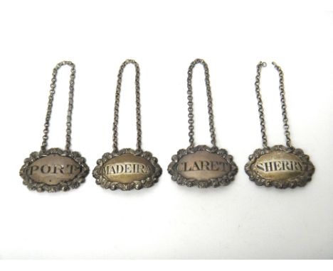 Four similar decanter labels, each of shaped oval form, with a cartouche shaped border, comprising; Madeira, probably London 