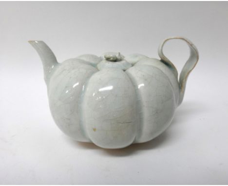 A Chinese Qingpai teapot and cover, Song dynasty or later, of melon form with strap handle, covered in a light blue glaze, 8.