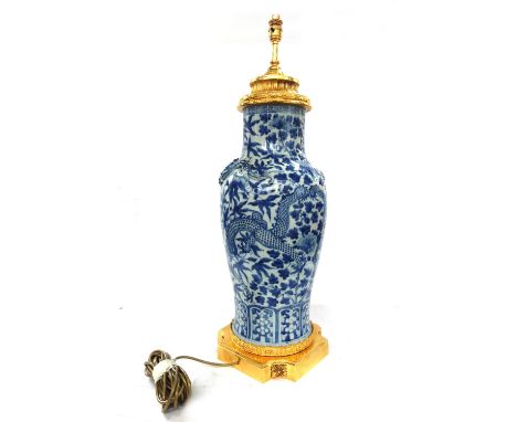 A Chinese porcelain and gilt brass mounted vase table lamp, 20th century, with applied dragons against a blue and white balus