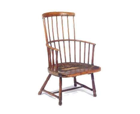 A George III elm seated comb back Windsor chair, on turned supports, retaining old traces of paint, 58cm wide x 97cm high x 5