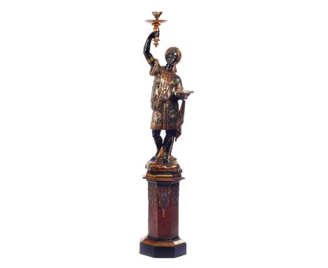 A late 19th century lamp modelled as a figure of a standing Blackamoor holding a torch, on stepped octagonal base, 204cm high