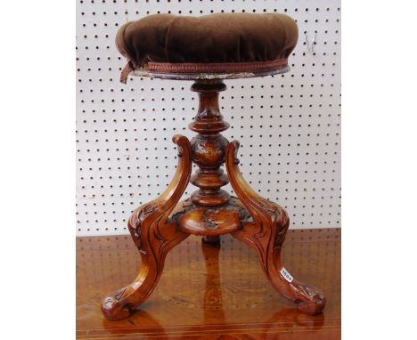 A Victorian stained beech piano stool, with circular height adjustable top on a carved tripod base, the top 34cm diameter.