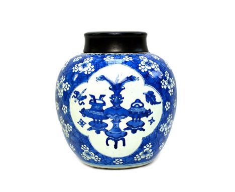 A Chinese blue and white ginger jar, Kangxi, painted with three barbed panels enclosing Precious Objects against a `cracked i