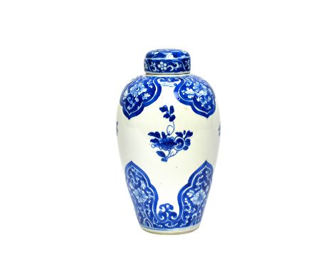 A Chinese blue and white vase and cover, Kangxi, of slender ovoid form, painted with barb shaped panels enclosing flowers aga