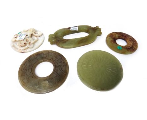 Five Chinese jade carvings, various colours, comprising; a circular dragon disc, 7cm.diameter; an oval disc with animal handl