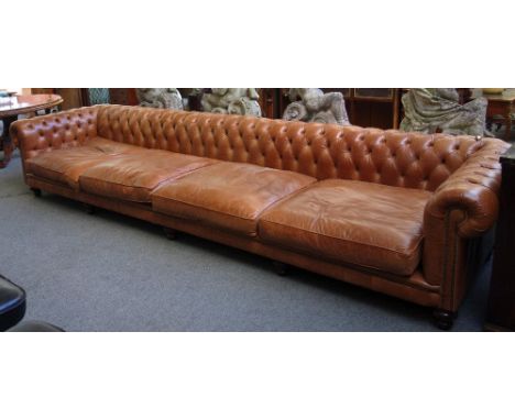 'Distinctive Chesterfields Hand Made in England'; a massive 20th century brown leather button upholstered Chesterfield sofa, 