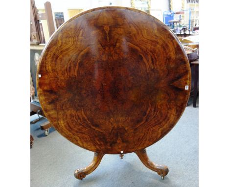 A Victorian figured walnut centre table, the circular snap top on carved tripod base, 120cm diameter x 76cm high. 