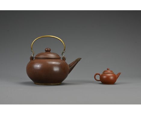 TWO CHINESE YIXING POTTERY TEAPOTS, 19TH CENTURY AND LATER. The larger pot with bronze handle and two character mark to base 