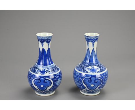 A PAIR OF CHINESE BLUE AND WHITE PORCELAIN VASES, 19/20TH CENTURY. Of baluster form decorated with ruyi heads on a floral gro