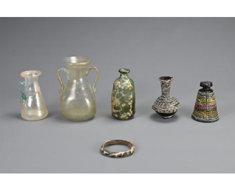 A GROUP OF GLASSWARE ITEMS, PROBABLY ROMAN AND LATER. To include two Phoenician glass vessels; Three glass bottle / jugs; Tog
