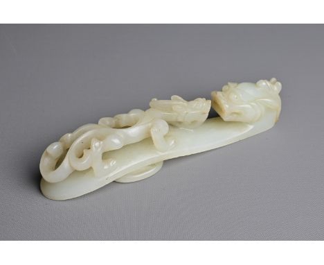 A LARGE CHINESE PALE CELADON JADE BELT HOOK, 18/19TH CENTURY. Carved and pierced section featuring a chilong and dragon head 
