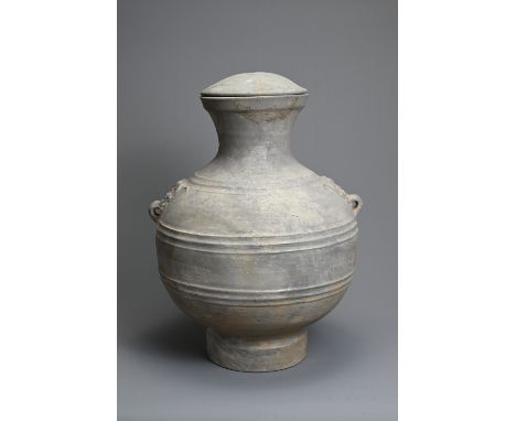 A LARGE CHINESE GREY POTTERY HU JAR WITH COVER, WESTERN HAN DYNASTY (206 BC – AD 8). Heavily potted of wide baluster form mad