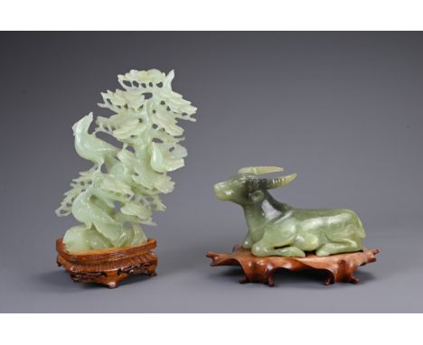 A CHINESE CARVED JADE MODEL OF A RECUMBENT WATER BUFFALO WITH SERPENTINE CARVING, 20TH CENTURY. The buffalo mounted on a carv