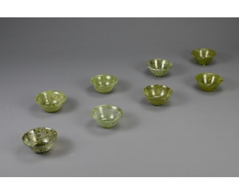 A GROUP OF EIGHT CHINESE SPINACH JADE BOWLS, 19/20TH CENTURY. Each with a rounded body and gently everted rim on a straight f