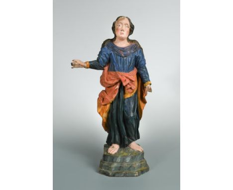 A late 18th or early 19th century Continental carved wood polychrome figure of a Saint, wearing a green coloured robe under a