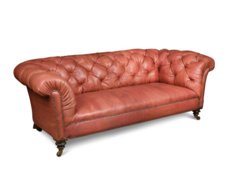 A 19th century Chesterfield sofa, with a low scroll back, recently upholstered in a button tan leather, on turned legs and ca