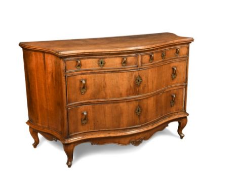 An 18th century Milanese walnut commode, of serpentine outline, with two short and two long drawers, brass leaf scroll handle