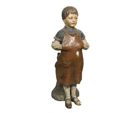 A late 19th century Austrian painted terracotta figure of a boy cobbler, possibly Goldscheider, he stands in front of a simul