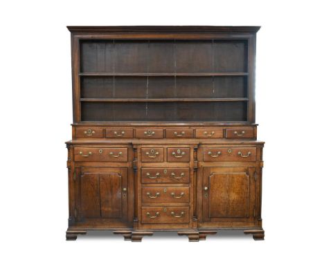 A George III Anglesey oak breakfront dresser, with raised plate rack, and bank of spice drawers, above seven further drawers 