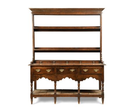 A late 18th century oak dresser, with open plate rack, raised bank of spice drawers and further drawers to an open base and p
