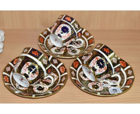 THREE ROYAL CROWN DERBY IMARI 1128 TEACUPS AND SAUCERS, having red printed backstamps, most pieces having a date cypher for 1