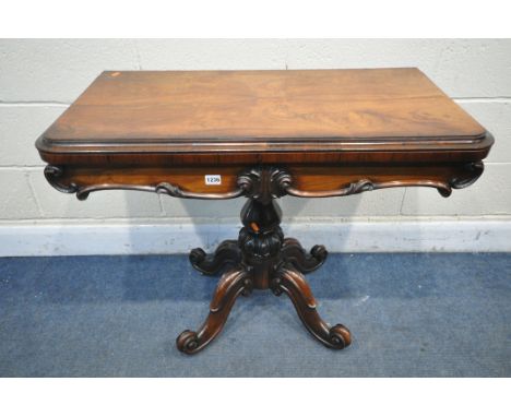 A VICTORIAN ROSEWOOD CARD TABLE, the fold over top enclosing a circular green baize playing surface, shaped apron, on a shape