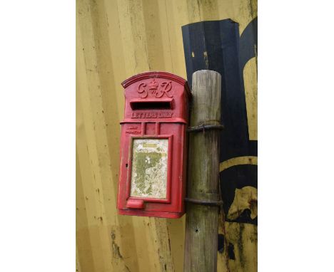 A GEORGE VI CAST IRON HANGING POST BOX with single door and lock (no key), painted in pillbox red, width 25cm, depth 34cm and