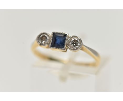 AN 18CT GOLD SAPPHIRE AND DIAMOND RING, designed with a square cut deep blue sapphire, in a milgrain collet setting, flanked 