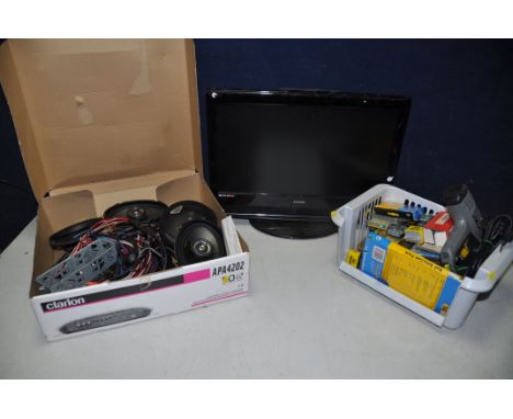 A E-MOTION W216-69G 21in TV with no remote, along with a box containing four car speakers and speaker wires, and a tray conta
