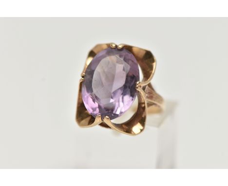 A 9CT GOLD AMETHYST RING, designed with a double four claw set, oval cut amethyst, measuring approximately length 16.9mm x wi