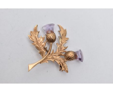 A 9CT GOLD THISTLE BROOCH, textured thistle brooch set with two faceted amethysts, fitted with a brooch pin and safety clasp,