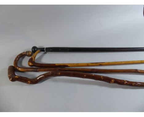 A Collection of Three Walking Sticks and One Ebonised Sword Stick 