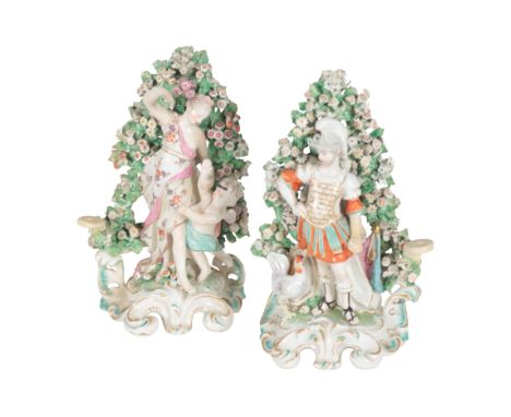 A PAIR OF 18TH CENTURY DUESBURY &amp; CO DERBY PORCELAIN CANDLESTICKS modelled respectively as a soldier and a maiden with ch