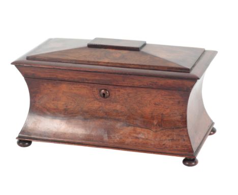 A VICTORIAN ROSEWOOD SARCOPHAGUS TEA CADDY the hinged lid opening to a lined interior, the body with waisted sides and standi