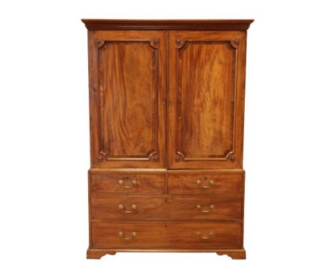 A GEORGE III MAHOGANY LINEN PRESS the top section with panelled doors with applied paterae to each corner, opening to an inte