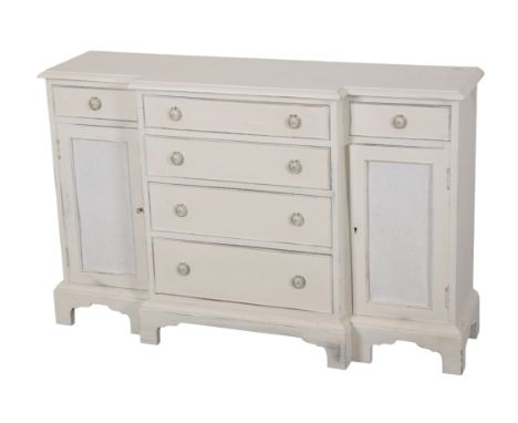 A WHITE-PAINTED BREAKFRONT SIDEBOARD 20th century, the moulded top over a central arrangement of graduating drawers, flanked 