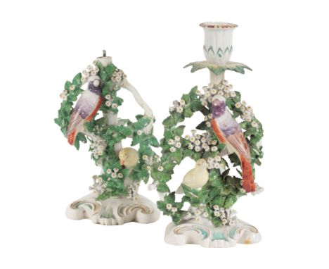 A PAIR OF 18TH CENTURY DUESBURY & CO DERBY PORCELAIN CHAMBERSTICKS modelled as exotic birds amongst foliage, 25cm high, one l