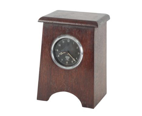 A SMITH'S EIGHT-DAY CAR CLOCK with black dial and white Arabic numerals, housed in an Arts and Crafts style oak case, 22cm hi
