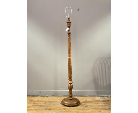 An Indian teak lamp standard, the turned and floral carved column on a circular base. H157cm.