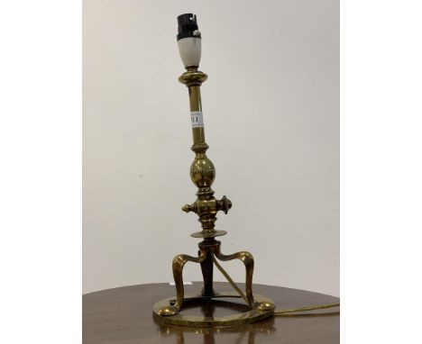 An early 20th century brass pullman table lamp, the articulated column raised on three splayed supports united by a circular 