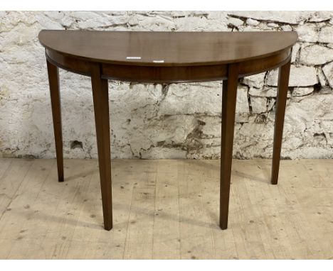 A George III style demi lune mahogany console table, early 20th century, the top over a figured frieze, raised on square tape