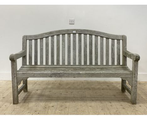 A silvered teak garden bench, with arched crest rail over slatted back and seat, raised on block supports H92cm, W150cm, D65c