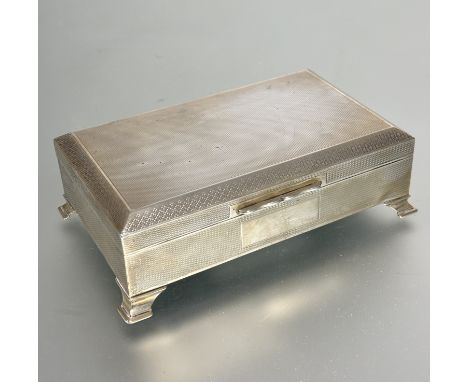 A Birmingham silver cigarette box, the rectangular box with all over engine turned decoration and cedar lined interior raised