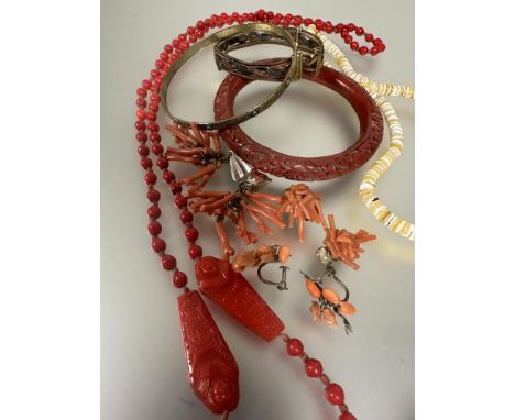 A 1920s Egyptian revival red vitralite bead necklace mounted with a pair of sarcophagus and tablet in matching red vitralite,